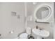 Small bathroom with white vanity, toilet, and round mirror at 6530 Stoller Ave, Windermere, FL 34786