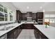 Kitchen features dark wood cabinets, tile backsplash and white countertops at 6530 Stoller Ave, Windermere, FL 34786