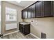 Laundry room with dark cabinets and granite countertop at 672 San Joaquin Rd, Kissimmee, FL 34759