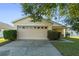 House exterior showcasing a two-car garage and neat landscaping at 8077 Roaring Creek Ct, Kissimmee, FL 34747