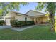 One-story house with attached garage, manicured lawn, and well-maintained landscaping at 8077 Roaring Creek Ct, Kissimmee, FL 34747