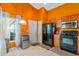 Orange-walled kitchen with wood cabinets, black appliances, and mini-fridge at 8077 Roaring Creek Ct, Kissimmee, FL 34747