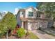 Two-story townhome with two-car garage, landscaped yard, and brick driveway at 8318 Quimby Cir, Davenport, FL 33896