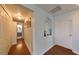 Bright hallway with wood floors, white doors, paneled walls, and decorative niche creates an inviting entry to the home at 8318 Quimby Cir, Davenport, FL 33896