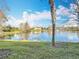 Scenic view of a peaceful lake with lush landscaping at 8318 Quimby Cir, Davenport, FL 33896