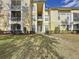 Exterior view of condo building with manicured landscaping and walkway at 8803 Dunes Ct # 306, Kissimmee, FL 34747