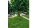 Landscaped backyard featuring a lush green lawn and stepping stone pathway through mature trees and shrubs at 12212 Holly Jane Ct, Orlando, FL 32824