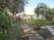 Landscaped backyard features a stone walkway, mature trees, and a garden trellis, ideal for outdoor relaxation at 12212 Holly Jane Ct, Orlando, FL 32824