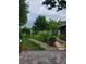 Tranquil backyard featuring stone pathway, mature trees, lush plants, and a peaceful patio area for outdoor enjoyment at 12212 Holly Jane Ct, Orlando, FL 32824
