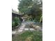 Serene backyard featuring a stone pathway, mature trees, and lush plants leading to a peaceful outdoor retreat at 12212 Holly Jane Ct, Orlando, FL 32824