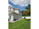 Side exterior of home with a green lawn, white fence, and palm tree at 12212 Holly Jane Ct, Orlando, FL 32824
