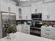 Well-equipped kitchen with white cabinets, stainless steel appliances, and a quartz countertop at 12212 Holly Jane Ct, Orlando, FL 32824
