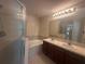 Well-appointed bathroom featuring dual sinks, tub, and walk-in shower at 10583 Regent Square Dr # 1206, Orlando, FL 32825
