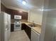 Well-lit kitchen featuring white appliances and dark wood cabinetry at 10583 Regent Square Dr # 1206, Orlando, FL 32825