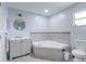Modern bathroom with a large corner soaking tub and gray tile at 1188 Anne Elisa Cir, St Cloud, FL 34772