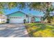 Charming light teal house with a white garage door and manicured lawn at 1188 Anne Elisa Cir, St Cloud, FL 34772