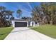Modern house with gray garage door and driveway; grassy yard at 13142 Sw 43Rd Avenue Rd, Ocala, FL 34473