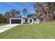 White house with gray garage door and landscaping; spacious lawn at 13142 Sw 43Rd Avenue Rd, Ocala, FL 34473