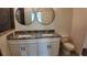 Bathroom with white vanity featuring double sinks, granite countertops, and tiled floors at 1321 Congo Dr, Kissimmee, FL 34759