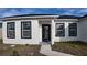 Inviting home entrance featuring a black front door, crisp white walls, and black trimmed windows at 1321 Congo Dr, Kissimmee, FL 34759