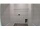 A laundry room with a wire shelf, white walls, and grey tile floor at 1321 Congo Dr, Kissimmee, FL 34759