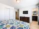 Main bedroom with TV and dresser; ensuite bathroom at 1610 Lima Ave, Kissimmee, FL 34747