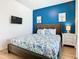 Primary bedroom with king bed, TV and light wood floors at 1610 Lima Ave, Kissimmee, FL 34747