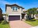 Two-story house with a brown garage door and landscaped yard at 1610 Lima Ave, Kissimmee, FL 34747