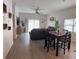 Open living and dining area with dark brown reclining sofas and wood-look floors at 19 James Ct, Davenport, FL 33837