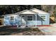 Newly renovated light blue house with white trim, grey walkway, and red mulch at 217 W Chelsea St, Deland, FL 32720