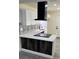 Modern kitchen with white cabinets, black range hood, and patterned backsplash at 217 W Chelsea St, Deland, FL 32720