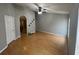 Large primary bedroom with wood floors, neutral paint, ceiling fan, and arched doorway at 228 Remington Pl, Haines City, FL 33844