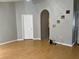 Open primary bedroom with wood floors, neutral paint, ceiling fan, and doorway to en-suite bathroom at 228 Remington Pl, Haines City, FL 33844