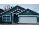 Teal house with white garage door and landscaping at 228 Remington Pl, Haines City, FL 33844