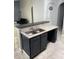 A breakfast bar features double sink, with gray countertops and cabinets at 228 Remington Pl, Haines City, FL 33844