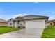 Gray house with white garage door and landscaping at 286 Begonia Ln, Kissimmee, FL 34759