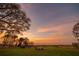 Stunning sunset over calm lake with firepit and chairs at 3000 Tohopekaliga Dr, St Cloud, FL 34772