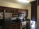 Galley kitchen features granite countertops, dark wood cabinetry, stainless appliances, and ample storage space at 3719 Conroy Rd # 2023, Orlando, FL 32839