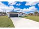 Single-story home with a two-car garage and landscaped lawn at 4690 Sw 139Th Place, Ocala, FL 34473