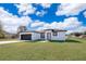 Single-story home with a two-car garage and landscaped lawn at 4690 Sw 139Th Place, Ocala, FL 34473