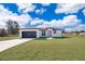 Single-story home with a two-car garage and landscaped lawn at 4690 Sw 139Th Place, Ocala, FL 34473