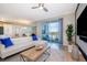 Living room with white sectional sofa and access to balcony at 4731 Clock Tower Dr # 206, Kissimmee, FL 34746