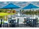 Relaxing lakeside patio with tables, chairs, and umbrellas; fountain view at 554 Heartwell Dr, Kissimmee, FL 34759