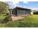Spacious screened-in porch with brick pavers and lush landscaping at 554 Heartwell Dr, Kissimmee, FL 34759