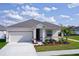 Newly built home with gray roof and landscaping at 566 Pawnee Ct, Haines City, FL 33844