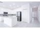 Modern kitchen with white cabinets, island, and stainless steel appliances at 566 Pawnee Ct, Haines City, FL 33844
