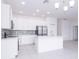 Modern kitchen with white cabinets, stainless steel appliances and mosaic backsplash at 566 Pawnee Ct, Haines City, FL 33844