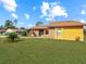 House exterior featuring a yellow single story home with a well-manicured lawn at 713 Green Ct, Kissimmee, FL 34759