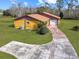 House exterior showcasing a yellow ranch-style home with a carport and spacious yard at 713 Green Ct, Kissimmee, FL 34759