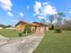 Exterior view of a yellow single story home with a driveway and lush lawn at 713 Green Ct, Kissimmee, FL 34759
